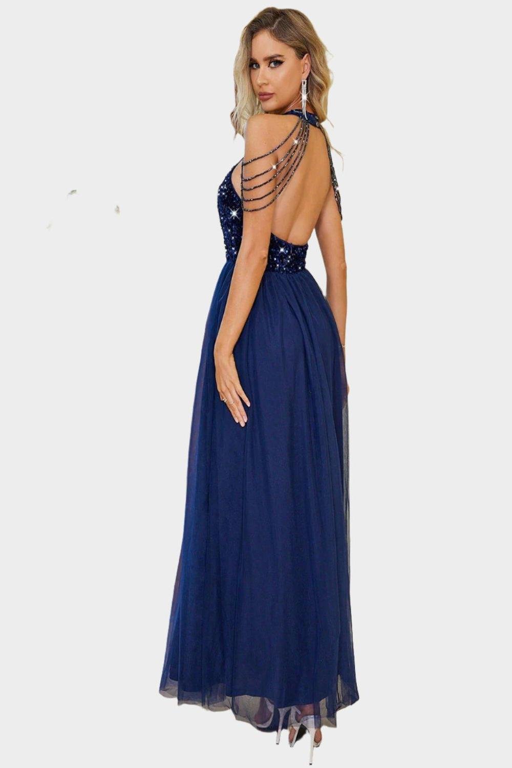 A stylish backless halter neck dress in a flowing fabric featuring a fitted bodice and an elegant open back design.