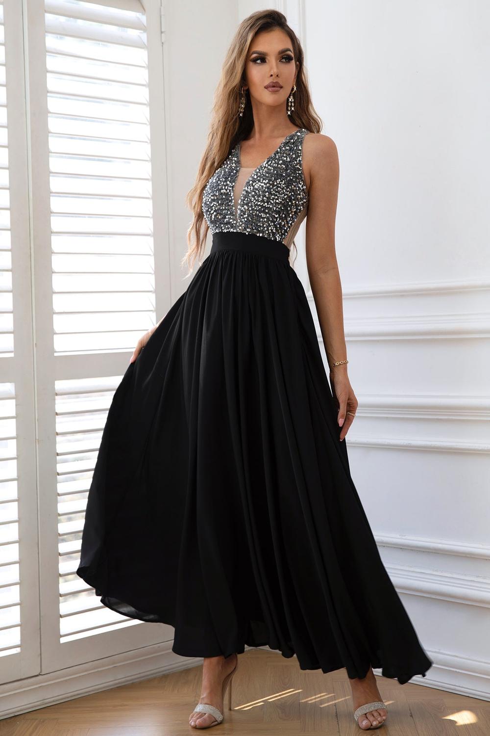  A stylish contrast sequin sleeveless maxi dress featuring a shimmering bodice with black and silver sequins flowing into a soft solid black skirt.