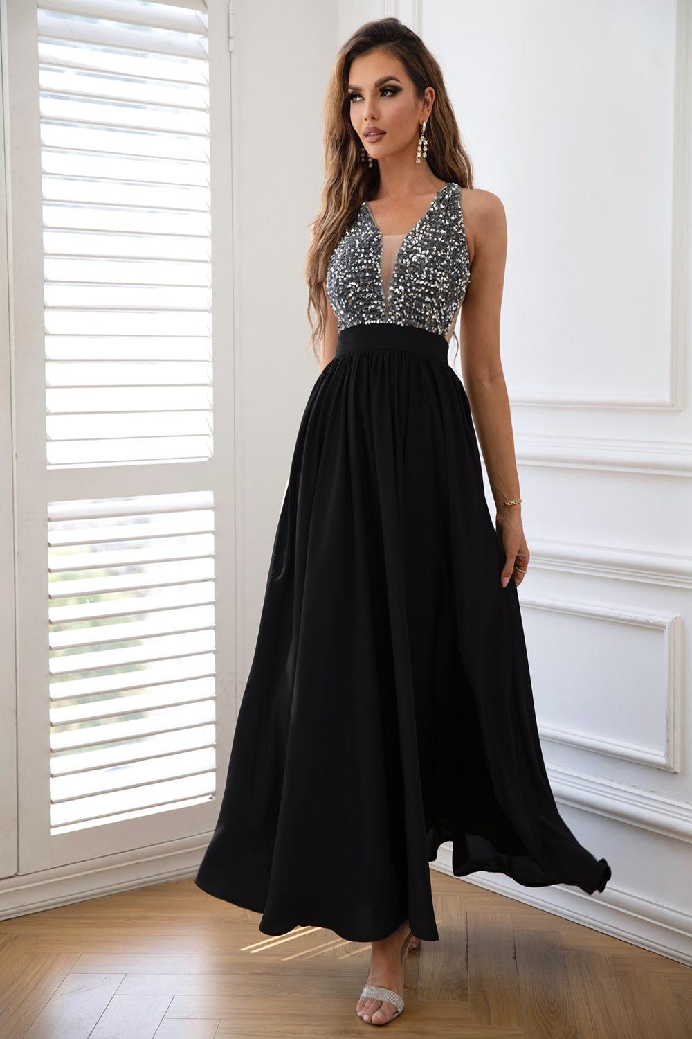  A stylish contrast sequin sleeveless maxi dress featuring a shimmering bodice with black and silver sequins flowing into a soft solid black skirt.