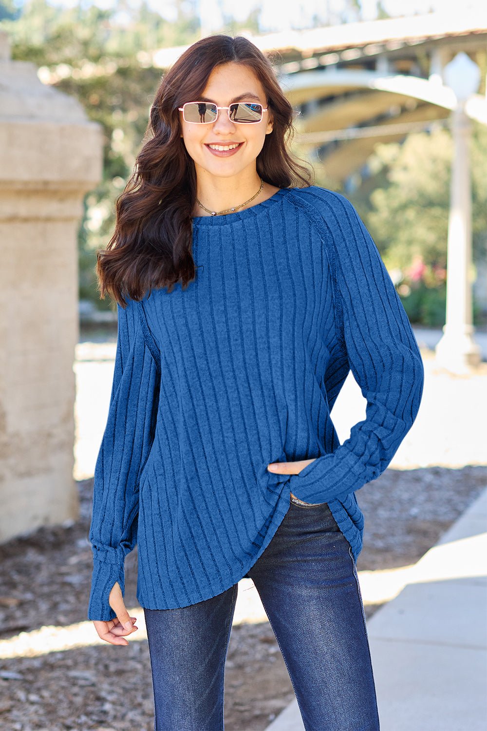 Full size ribbed round neck long sleeve knit top in a soft stretchy fabric featuring a fitted silhouette and subtle texture displayed on a neutral background.