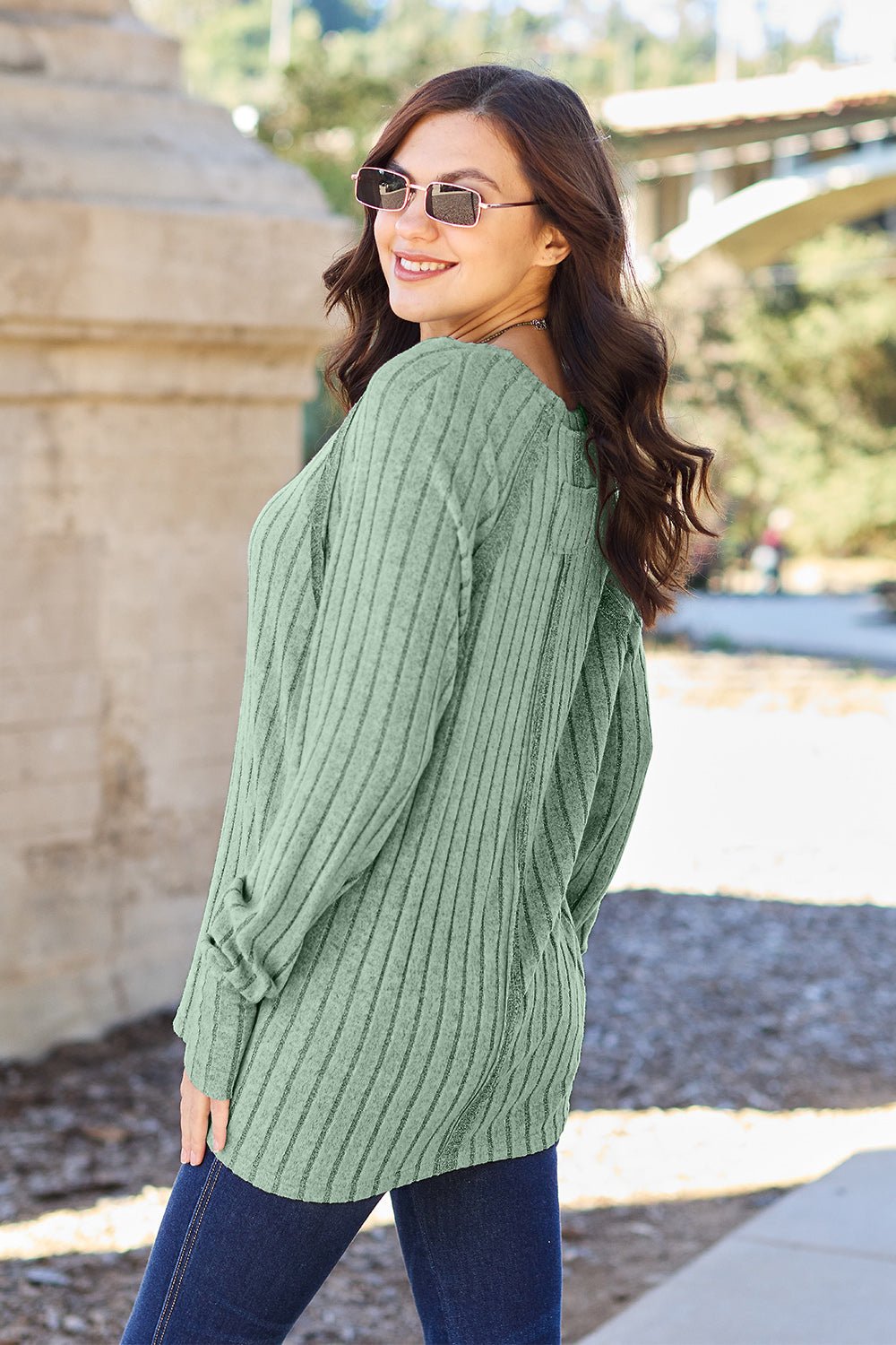 Full size ribbed round neck long sleeve knit top in a soft stretchy fabric featuring a fitted silhouette and subtle texture displayed on a neutral background.