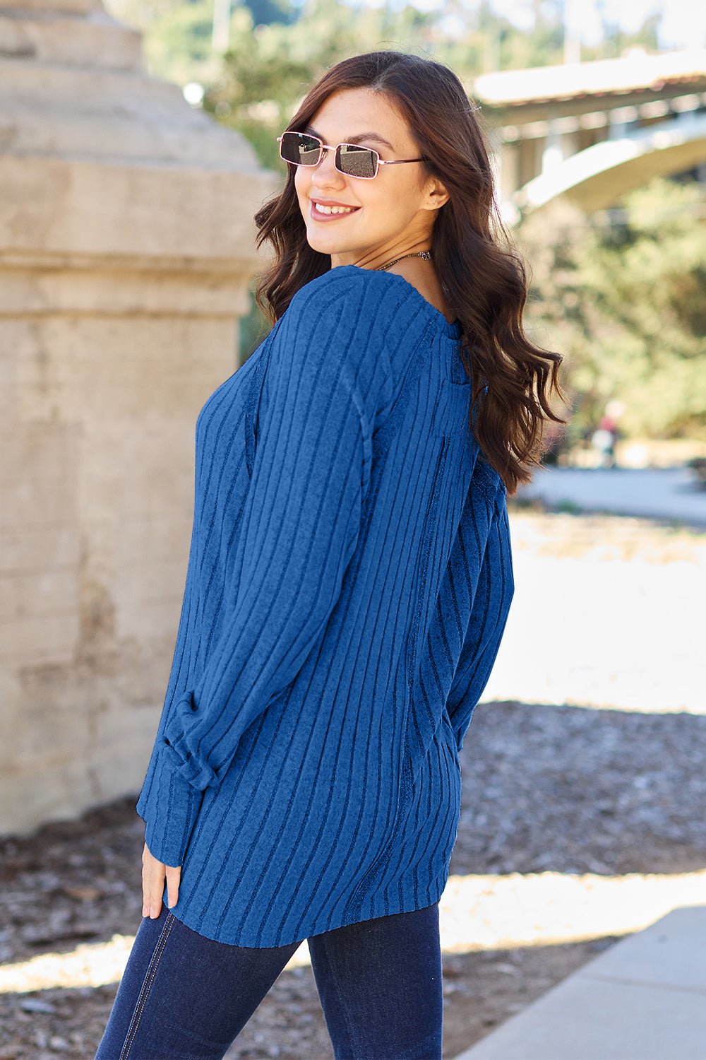 Full size ribbed round neck long sleeve knit top in a soft stretchy fabric featuring a fitted silhouette and subtle texture displayed on a neutral background.