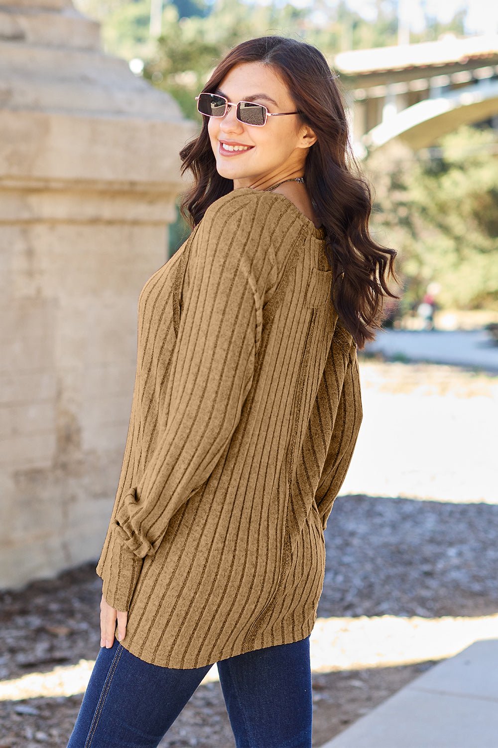 Full size ribbed round neck long sleeve knit top in a soft stretchy fabric featuring a fitted silhouette and subtle texture displayed on a neutral background.