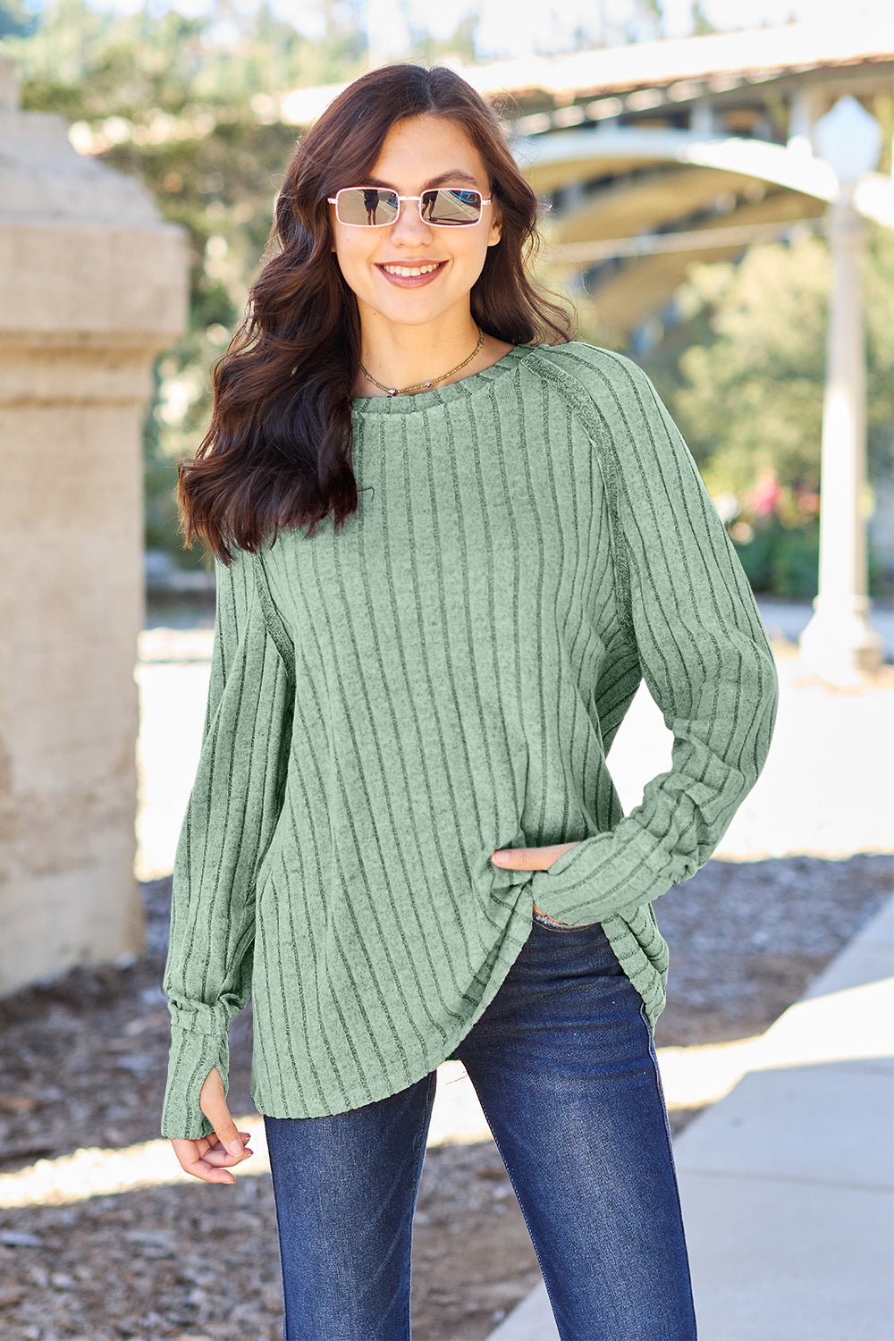 Full size ribbed round neck long sleeve knit top in a soft stretchy fabric featuring a fitted silhouette and subtle texture displayed on a neutral background.