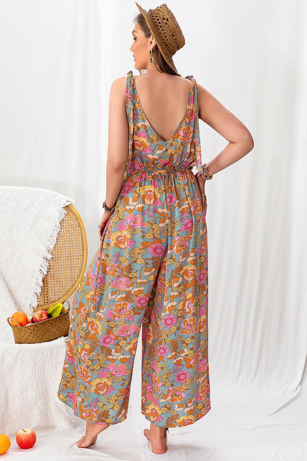 A stylish plussize woman wearing a colorful printed wideleg sleeveless jumpsuit featuring a flattering silhouette and a vibrant pattern standing against a neutral background.