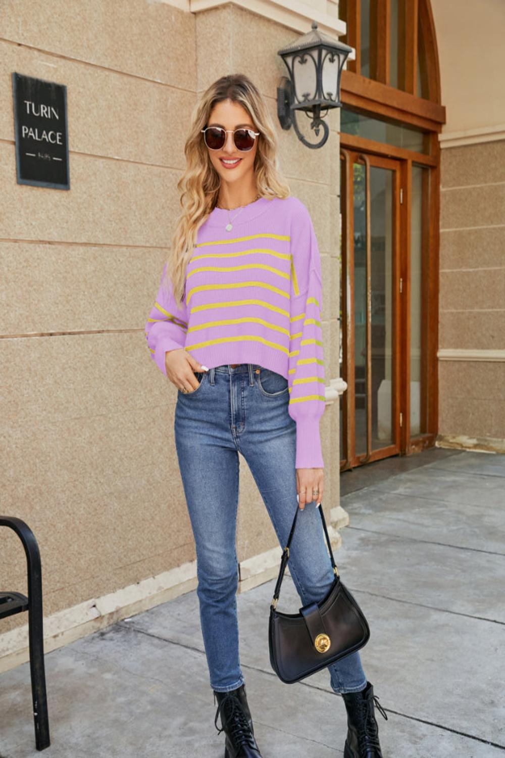  A round neck striped sweater featuring lantern sleeves showcasing a blend of vibrant colors and a cozy knit texture.