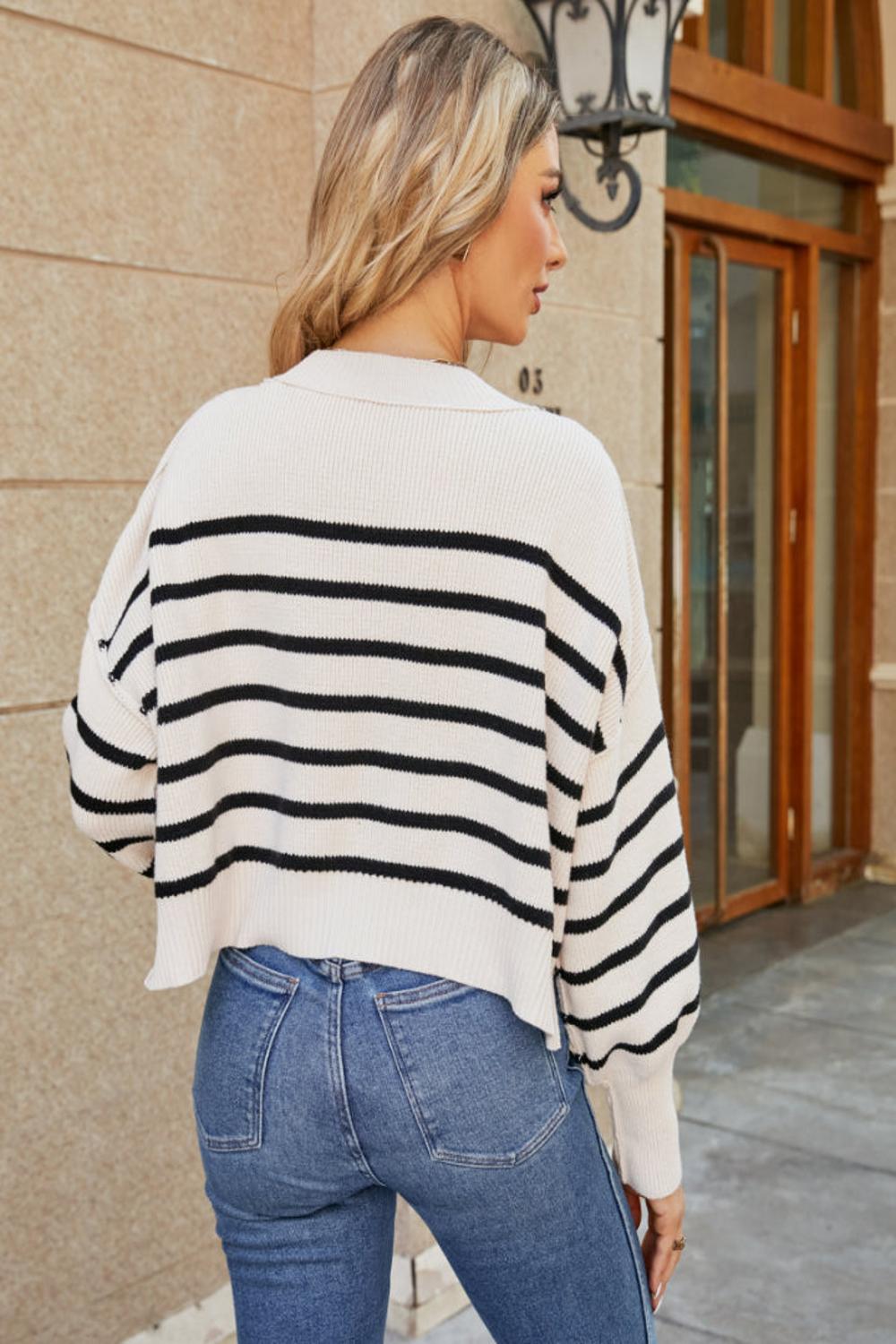  A round neck striped sweater featuring lantern sleeves showcasing a blend of vibrant colors and a cozy knit texture.