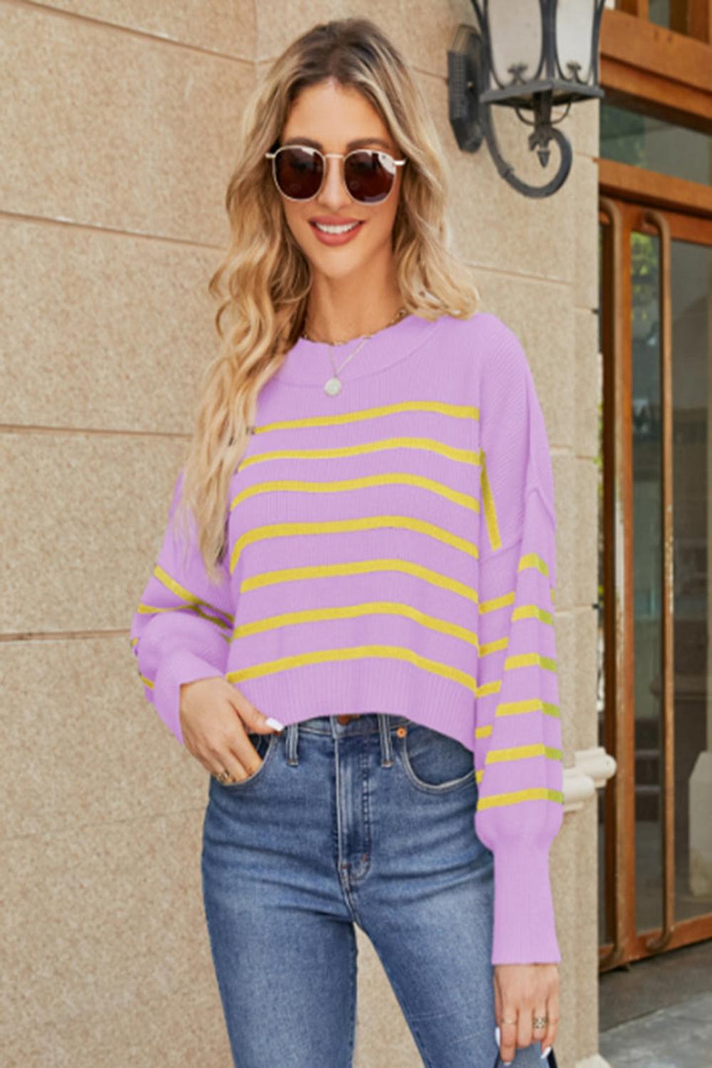  A round neck striped sweater featuring lantern sleeves showcasing a blend of vibrant colors and a cozy knit texture.