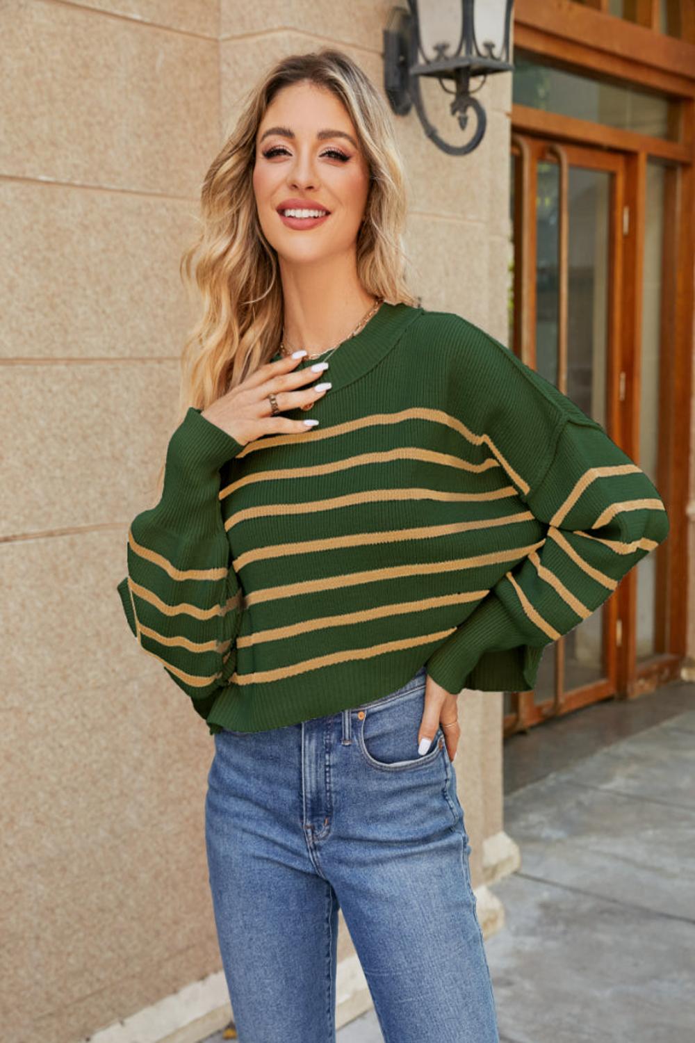  A round neck striped sweater featuring lantern sleeves showcasing a blend of vibrant colors and a cozy knit texture.