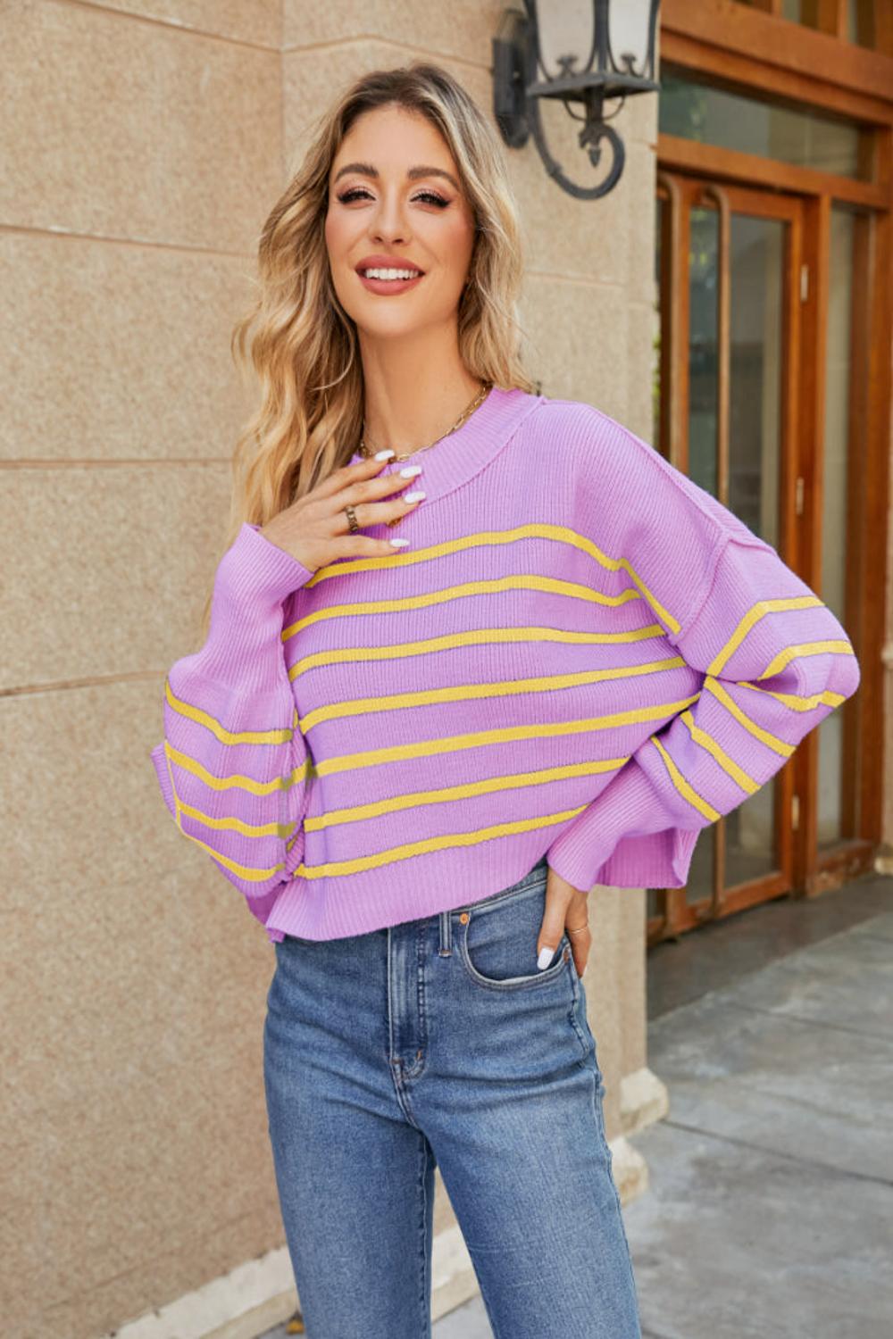  A round neck striped sweater featuring lantern sleeves showcasing a blend of vibrant colors and a cozy knit texture.