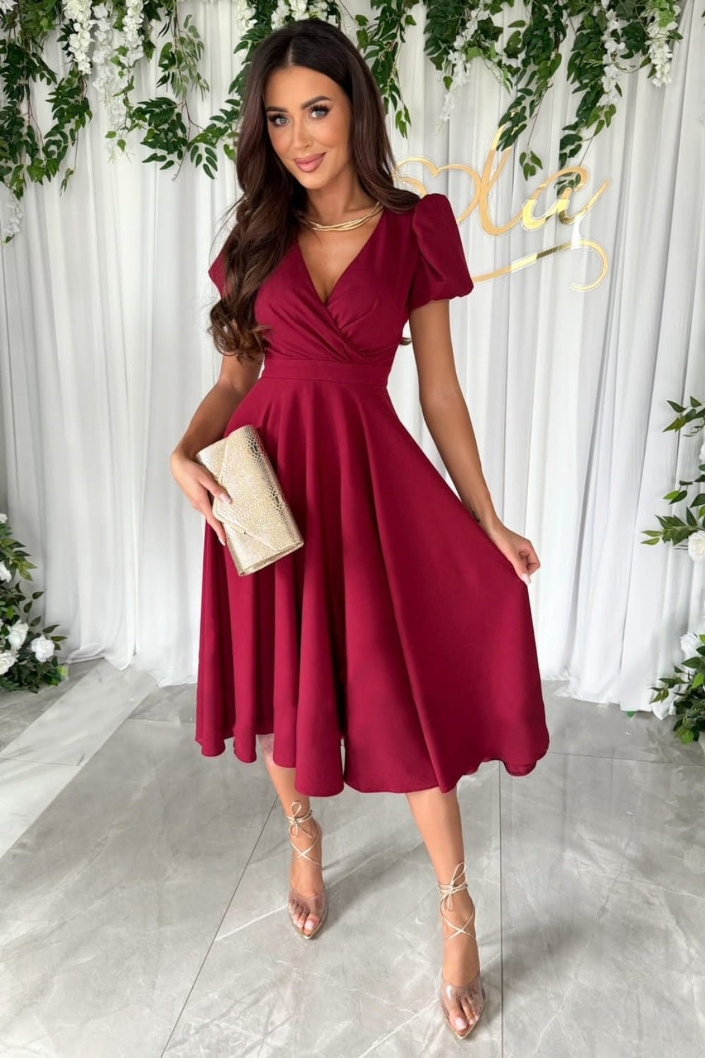 Elegant surplice midi dress featuring puff sleeves a fitted waist and a flowing skirt in a soft fabric perfect for a stylish occasion.