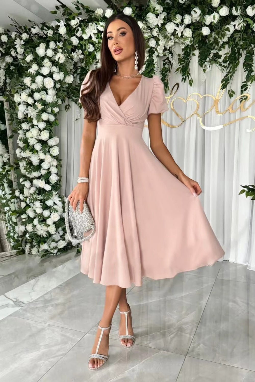 Elegant surplice midi dress featuring puff sleeves a fitted waist and a flowing skirt in a soft fabric perfect for a stylish occasion.