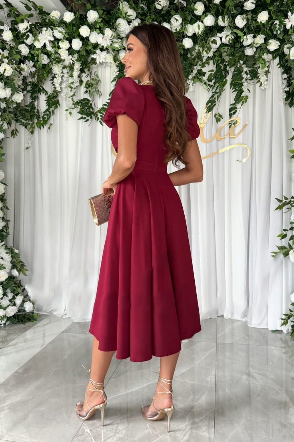 Elegant surplice midi dress featuring puff sleeves a fitted waist and a flowing skirt in a soft fabric perfect for a stylish occasion.