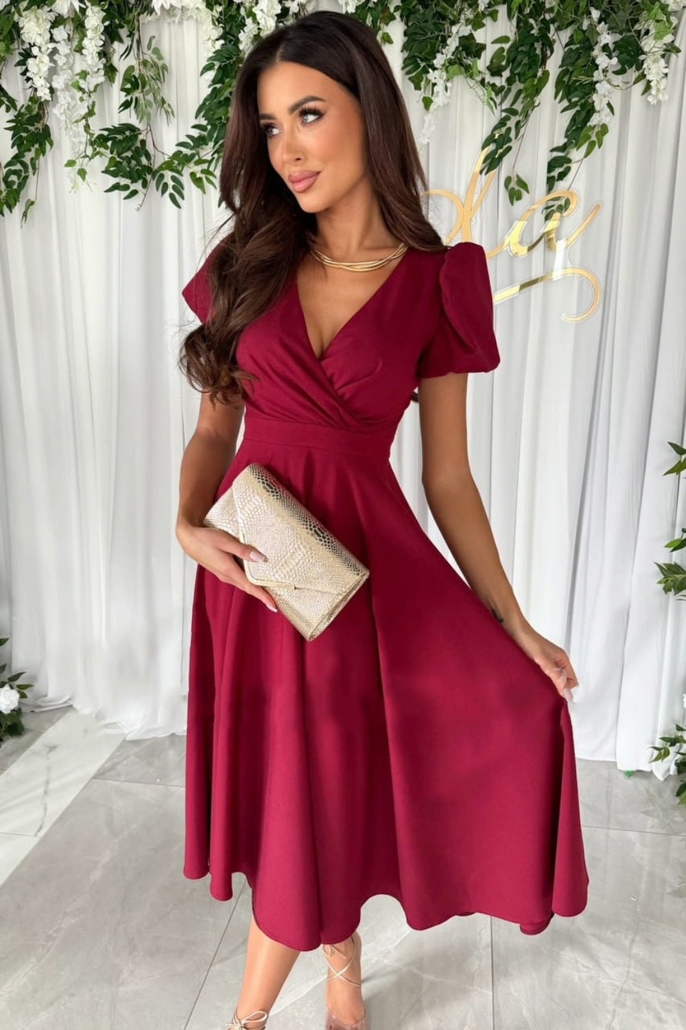 Elegant surplice midi dress featuring puff sleeves a fitted waist and a flowing skirt in a soft fabric perfect for a stylish occasion.