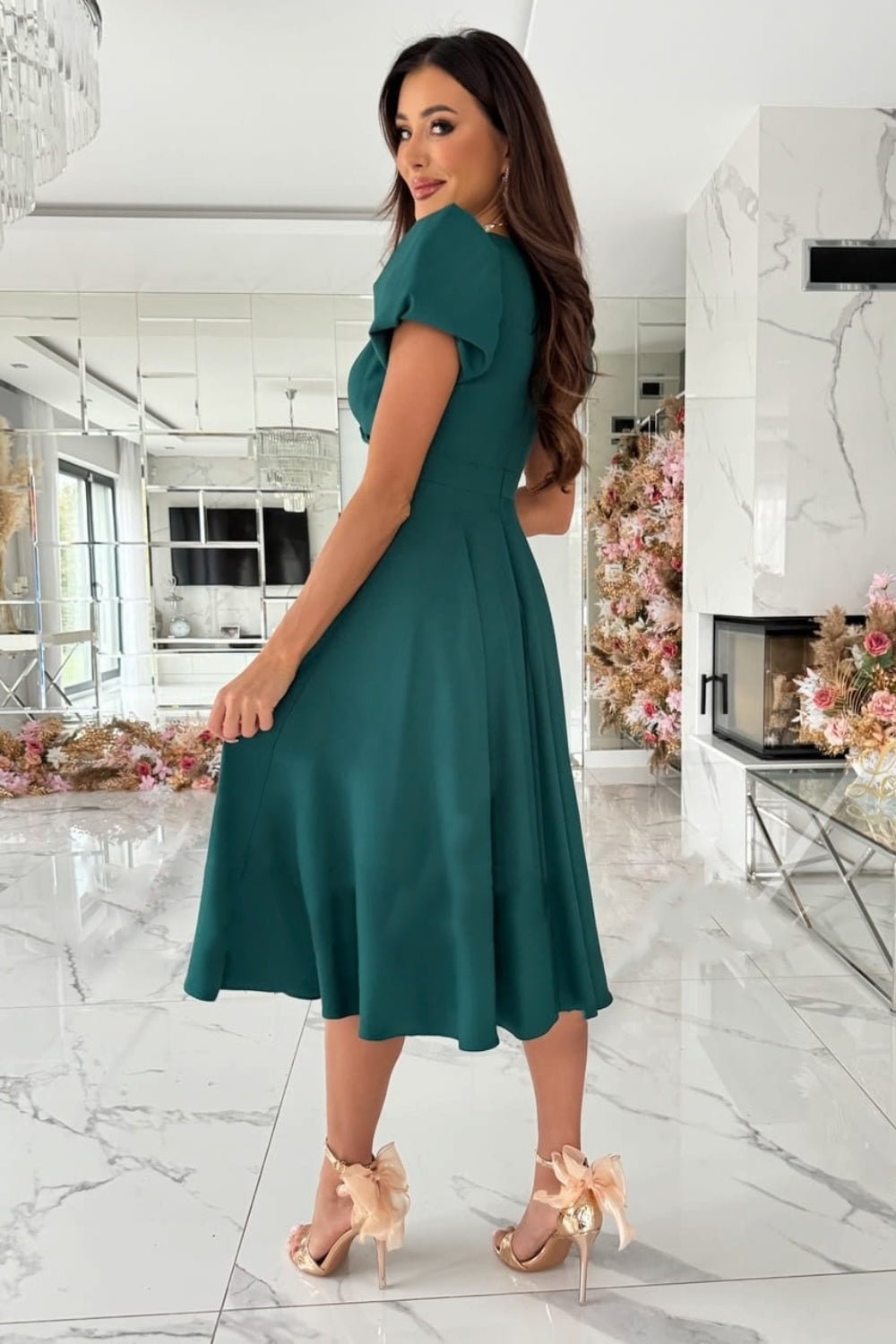 Elegant surplice midi dress featuring puff sleeves a fitted waist and a flowing skirt in a soft fabric perfect for a stylish occasion.